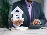 man holding toy house